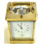 Clock Brass cased carriage clock, unusual movement chiming, in working order, damage to the door and