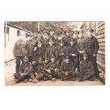 Postcard-The Queen's Regiment WWI RP Platoon with Bugler outside Barrack hut