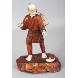 A JAPANESE MEIJI PERIOD WOOD & IVORY OKIMONO OF A FISHERMAN, the man standing and with a basket of