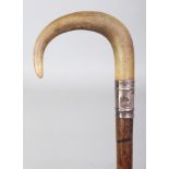 ANOTHER RHINO HORN HANDLED BAMBOO WALKING STICK, with an embossed and hallmarked silver collar,