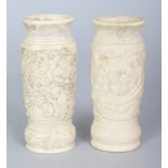 A SMALL PAIR OF JAPANESE MEIJI PERIOD BONE VASES, each carved in deep relief to the sides with an
