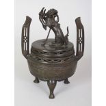 A JAPANESE MEIJI PERIOD BRONZE TRIPOD KORO & COVER, the cover cast with a shi-shi holding aloft a