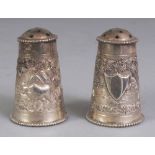 A PAIR OF EARLY/MID 20TH CENTURY INDIAN SILVER-METAL PEPPERETTES, weighing approx. 58gm, one with