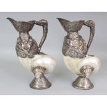 AN UNUSUAL PAIR OF TIBETAN SILVER-METAL MOUNTED NAUTILUS SHELLS, each shell with elaborately