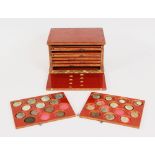 A SMALL EIGHT DRAWER TUFNOL COIN CABINET, with a collection of Roman and Greek coins (74). 5ins long