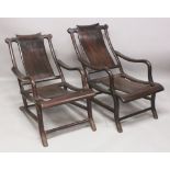 . A PAIR OF GOOD QUALITY CHINESE CARVED HARDWOOD RECLINING CHAIRS, 38in long overall & 22.5in wide &