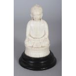 A JAPANESE MEIJI PERIOD IVORY OKIMONO OF BUDDHA, mounted on a wood stand, the Buddha seated in