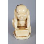 A SMALL SIGNED JAPANESE MEIJI PERIOD IVORY OKIMONO OF A MAN KNEELING BEFORE A BOX, a rat on his