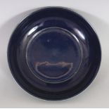 A CHINESE MING STYLE BLUE GLAZED PORCELAIN DISH, of saucer shape with an everted rim, the base