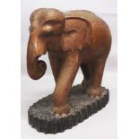 A LARGE 20TH CENTURY INDIAN LACQUERED WOOD & GLASS INLAID MODEL OF AN ELEPHANT, approx 29in long &