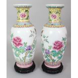 A PAIR OF 20TH CENTURY CHINESE FAMILLE ROSE PORCELAIN VASES, together with a fitted wood stands,