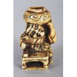 A GOOD JAPANESE EDO/MEIJI PERIOD IVORY NETSUKE OF SHOKI, crouching before a low table and supporting