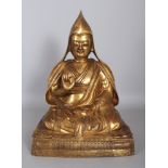 A LARGE GOOD QUALITY TIBETAN GILT BRONZE FIGURE OF A LAMA, possibly 18th/19th Century, the priest