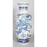 A CHINESE COPPER RED & UNDERGLAZE BLUE PORCELAIN ROULEAU DRAGON VASE, 11.4in high.