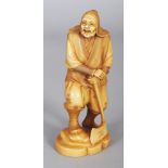 A SIGNED JAPANESE MEIJI PERIOD STAINED IVORY OKIMONO OF A WOODSMAN, leaning on an axe, the base