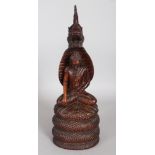 A 19TH CENTURY BURMESE CARVED HARDWOOD FIGURE OF BUDDHA, seated in meditation on the coiled body