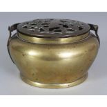 A 19TH/20TH CENTURY CHINESE CIRCULAR BRONZE HAND WARMER, with pierced cover and swing handle, 4.