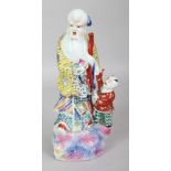 AN EARLY 20TH CENTURY CHINESE FAMILLE ROSE PORCELAIN FIGURE OF SHOU LAO, standing on rockwork
