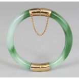 A CHINESE CELADON & DARK GREEN JADE-LIKE GLASS BANGLE, opening on a hinge with gilt metal fittings