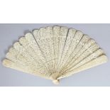 A 19TH CENTURY CHINESE CANTON IVORY FAN, with sixteen pierced and carved inner sticks, the guard