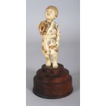 A JAPANESE MEIJI PERIOD SHIBAYAMA STYLE MOTHER-OF-PEARL ONLAID IVORY OKIMONO OF A STANDING BOY,