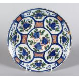 AN 18TH CENTURY DELFT CIRCULAR PLATE, decorated with stylised flowers. 9ins diameter.