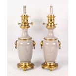 A GOOD PAIR OF LOUIS XVI DESIGN GREEN PORCELAIN AND ORMOLU LAMPS with lion ring handles and circular
