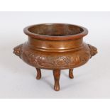 A CHINESE BRONZE CENSER, with lion mask handles, on three curving legs. 6ins wide.