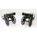 A PAIR OF 19TH CENTURY BLACK PATINATED, MOUNTED CAST IRON CANNONS. 62ins long, 28ins high, 16ins