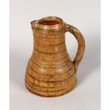 A LARGE STUDIO POTTERY JUG, with rope work handle. Impressed B in a circle. 8.5ins high.