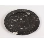 A BLACK FOSSIL CIRCULAR PLATE.