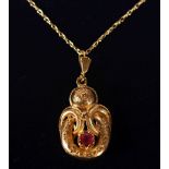 A 9CT GOLD VICTORIAN STYLE RUBY SET PENDANT AND CHAIN.