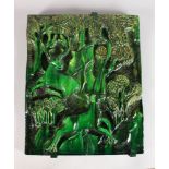 A GREEN ART DECO POTTERY PLAQUE with deer in a landscape in relief. 16ins x 13ins.