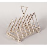 A PLATED TRIANGULAR DESIGN TOAST RACK on ball feet. 6.5ins.