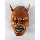 A CARVED WOODEN DEVIL MASK. 3ins.