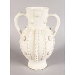 A WHITE GLAZED TWO-HANDLED POTTERY VASE. 13ins high.