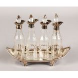 A GEORGE III FOUR BOTTLE BOAT SHAPED CRUET, with silver top bottles, reeded edge on four curving