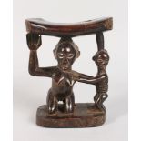 A CARVED TRIBAL NECK REST, "MOTHER AND CHILD". 7ins high.