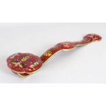 A CHINESE CLOISONNE RUYI SCEPTRE, red ground, decorated with bats and flowers. 1ft 4ins long.