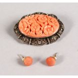 A CARVED CORAL AND SILVER OVAL BROOCH AND EARRINGS.