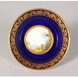 AN 18TH CENTURY SEVRES SAUCER, painted with a landscape surrounded by a blue ground with an