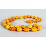 AN EGG YOLK/BUTTERSCOTCH AMBER BEAD NECKLACE, comprising 43 graduated beads with 9ct gold clasp,
