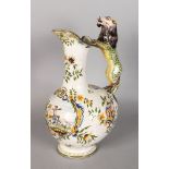 A CONTINENTAL FAIENCE POTTERY JUG, with lion handle, the fruit painted with a man with a two