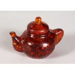 A SMALL AMBER TEAPOT. 2.5ins high.