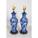 A PAIR OF CHINESE BLUE AND WHITE PORCELAIN PRUNUS PATTERN VASES, fitted for electricity. 1ft 7ins