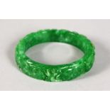 A CARVED APPLE GREEN JADE BANGLE.