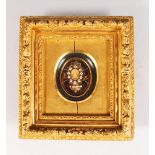 A RELIGIOUS ROLLED PAPER RELIQUARY in a gilt frame.