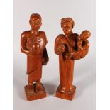 A PAIR OF AFRICAN WOODEN CARVED FIGURES, a woman holding a child, the man a religious orb. 15ins