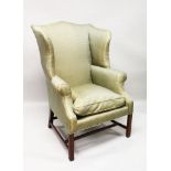 A GEORGE III DESIGN MAHOGANY WING ARMCHAIR, with padded back, arms and seat, supported on square