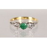 A YELLOW GOLD THREE-STONE EMERALD AND DIAMOND RING.